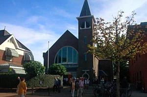 Op de foto is te zien dat mensen een kerk binnenlopen.