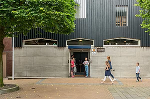 Op de foto is een gebouw te zien waar mensen op te zien zijn.