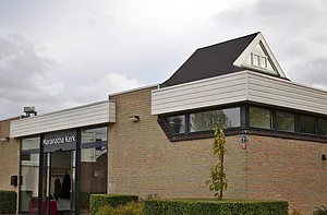 Op de foto is een gebouw te zien met een bewolkte lucht.