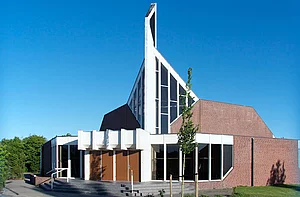 Op de foto is een kerk te zien met een blauwe lucht op de achtergrond