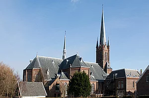 Op de foto is een kerk met een blauwe lucht op de achtergrond te zien